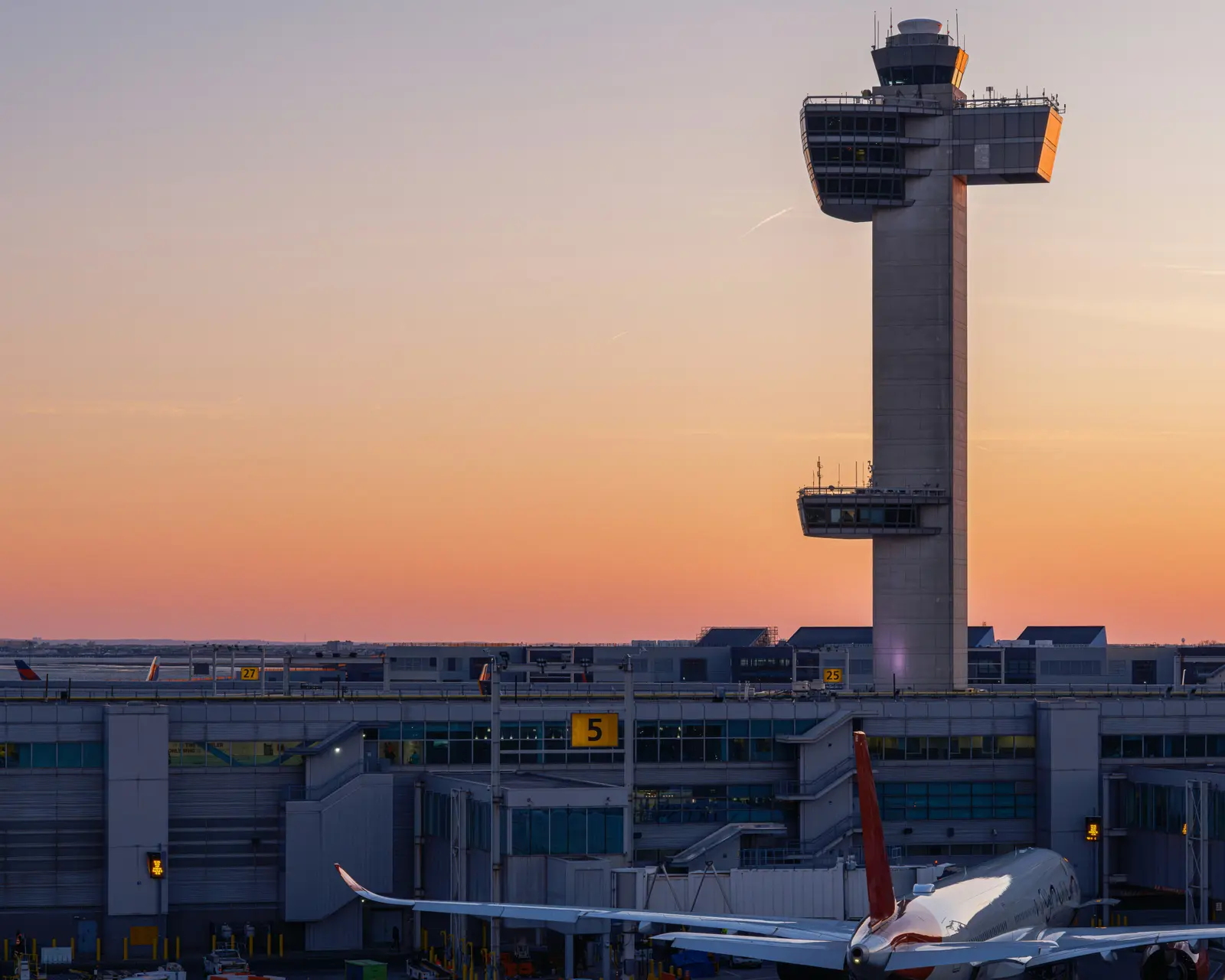 A control tower with a Virgin Atlantic aircraft beside it.