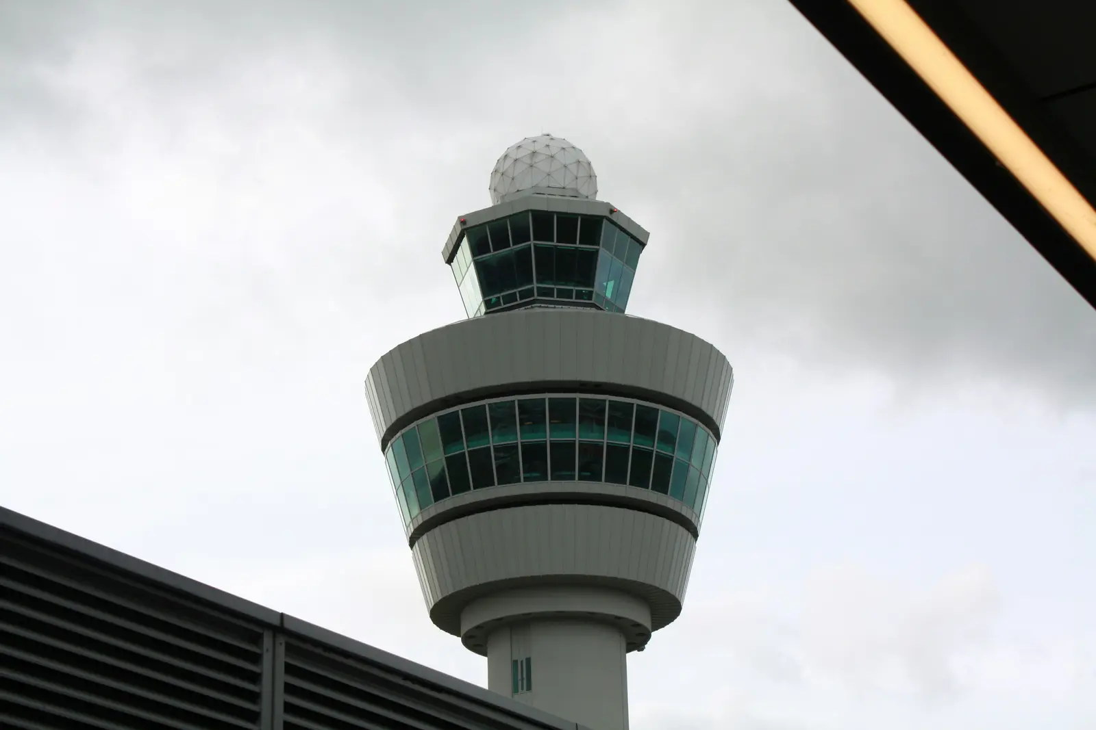 The control tower at Amsterdam Schiphol Airport, with a radar dome above the cab.